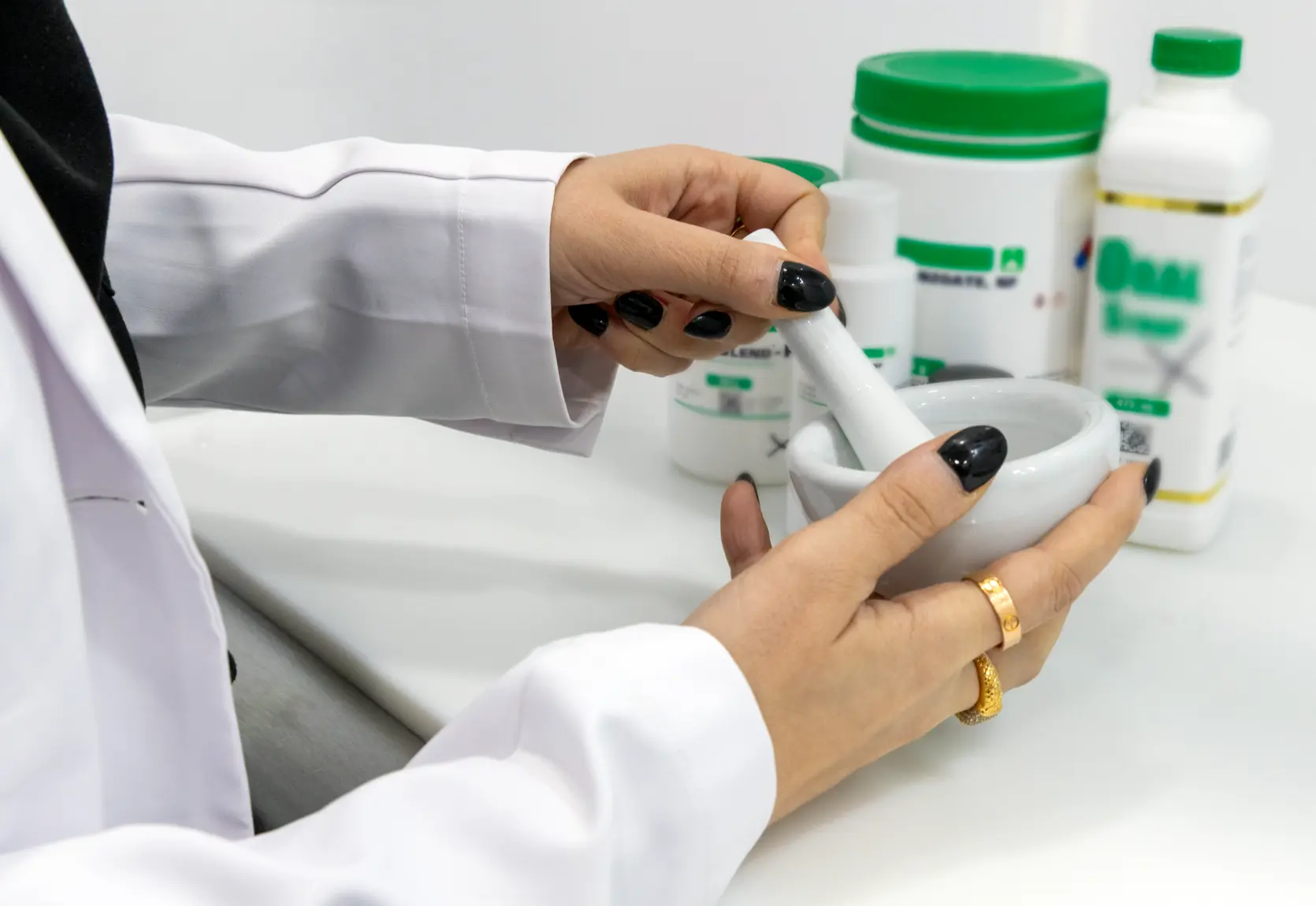 A pharmacist preparing a compounded medication with a mortar and pestle