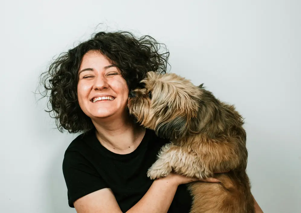 A smiling woman holding her dog