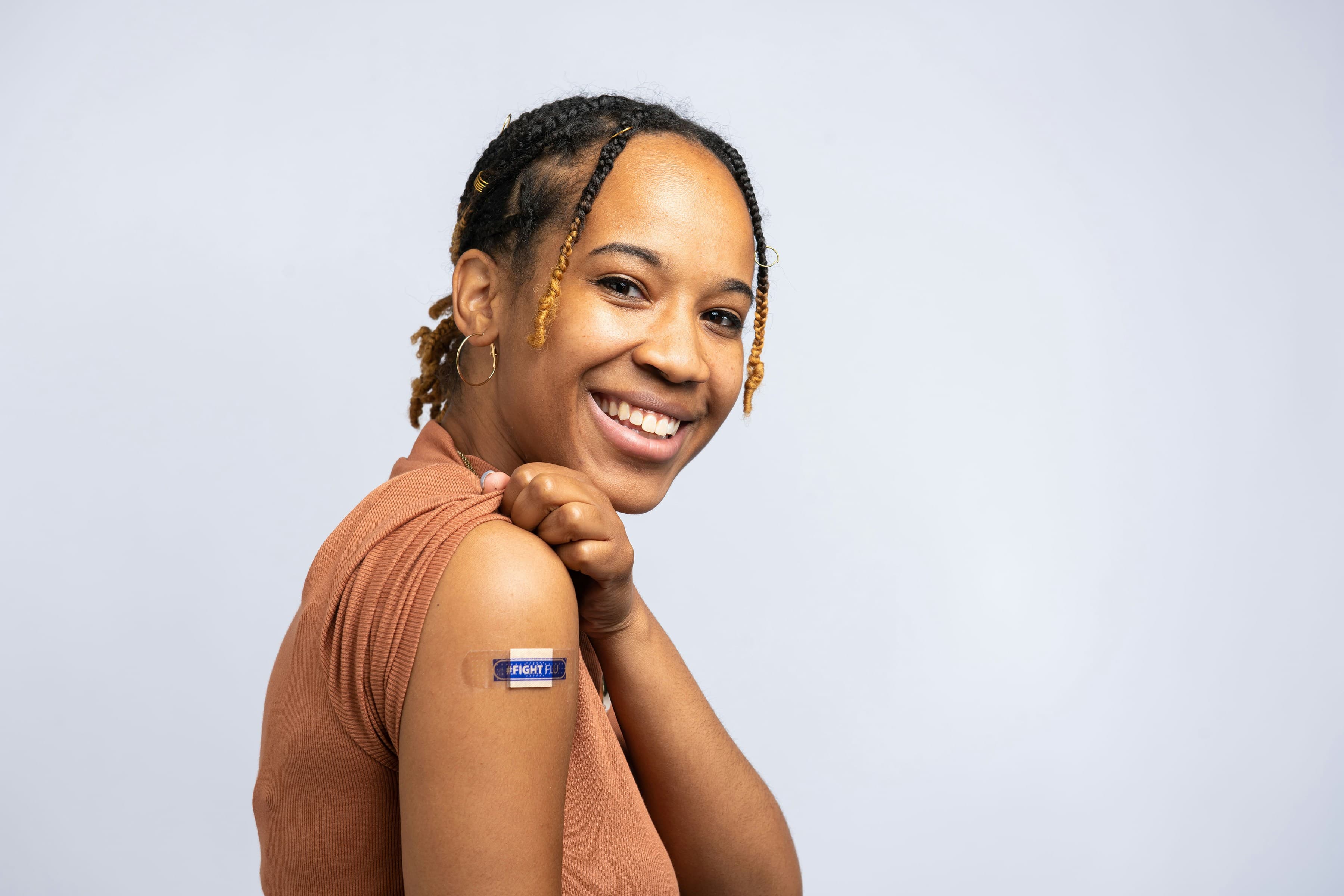 A smiling patient with a vaccine bandage